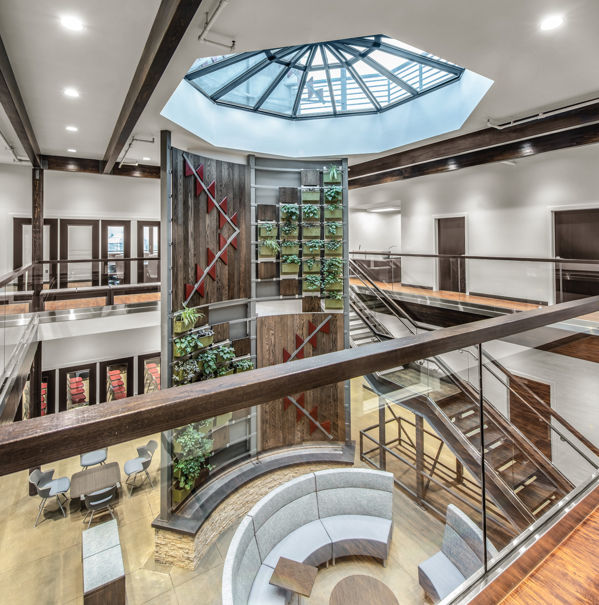 Bright white downlights surround a large round skylight, illuminating a square common area with a large decorative centerpiece