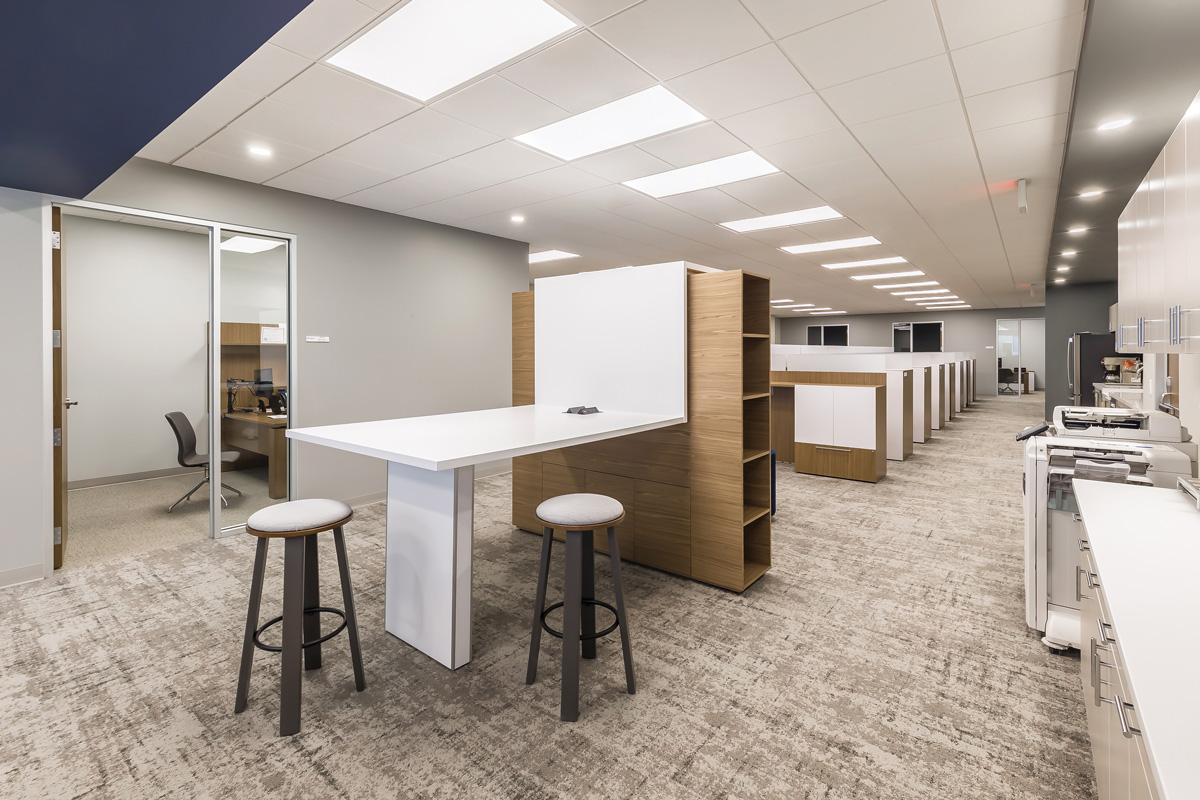 Flat panels and downlights illuminate mid-century modern open-plan office space