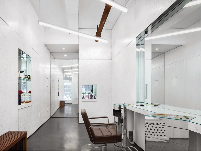 LLM suspended and 2DR downlights provide ambient lighting in chic hair salon.